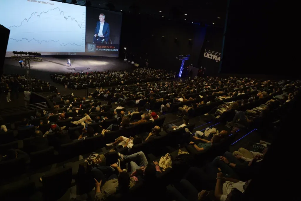 Auditorio lleno durante una edición anterior del evento de Pablo Gil, con el escenario y una pantalla grande al fondo